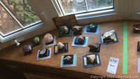 Overview of thirteen assorted mineral specimens on black presentation stands with certificates from Franklin Mint