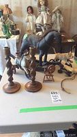 Four pull toys, two wooden barley twist candle holders, and vintage dolls on table