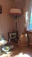 Full view of vintage floor lamp with lampshade and second lampshade beside it, alongside framed rabbit print.