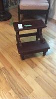 Full view of the small mahogany bed stool from the front showing both steps and turned legs.