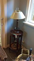 Full view of antique wood cane table, vintage metal lamp, and clock displayed on lower shelf