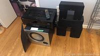 Receiver, subwoofer, remote and all speakers arranged on floor