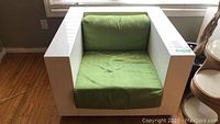 Front view of one Poltronova Saratoga Cube armchair showing white box frame and green seat cushion.