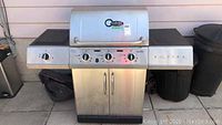 Front view of the stainless steel Char-Broil barbecue with side burner and two cabinet doors below, showing overall size and condition.
