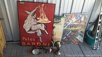 View of the posters including Pates Baroni, Indian Motorcycle, Asia Town at Night, and two desk lamps including clip-on flexible and folk art knight figurine lamp.