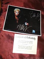 Photo of the signed 8x10 Billy Idol photo showing two signatures in silver ink on dark background.