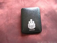 Closed black protective case with Canada crest on top, textured surface.