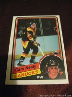 Front side of 1984-85 O-Pee-Chee hockey card showing Cam Neely in Vancouver Canucks colors with inset headshot, card number 327 and player name.