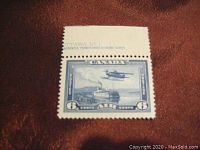 Front view of 1938 Canada airmail stamp C6 with monoplane over Mackenzie River design, showing top margin inscription.