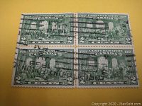 Front side view of the block of four green Canadian postage stamps featuring Fathers of Confederation with cancellation marks.