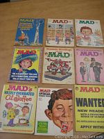 Top-down photo showing all nine MAD Magazines arranged in rows on a wooden surface, highlighting varied illustrated covers and colorful designs.