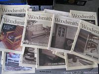 Top view of various Woodsmith magazine covers showing woodworking projects such as rocking chair, jewelry case, porch swing-glider, bunk beds, steamer trunk.