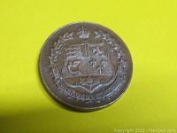 Front side photo showing detailed coat of arms design on the 1927 token with crown and wreath.