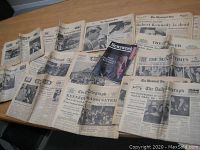 A collection of old newspapers and a Newsweek magazine arranged on a table with headlines referencing JFK and RFK assassinations.