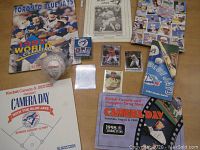 Full view of collection including signed baseball, program books, newspaper clipping, and camera event cards.