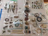 Wide view of multiple watches, bracelets, and assorted jewelry pieces laid out on a white surface.