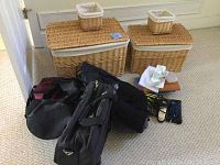 Four wicker baskets including two large rectangular wicker baskets with lids and fabric linings plus two smaller square lined wicker baskets, various travel bags and accessories.