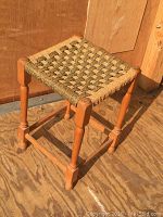 Side view of the woven top stool showing natural wood finish and construction.
