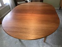 Top view of oval teak table in closed position
