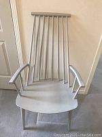 Front view of white painted wooden high-back armchair