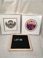 Two framed Indigenous art prints side by side with label 'LOT 49' in front.