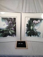 Set of two framed botanical lithographs of orchids, placed side by side, with a small board showing lot number.