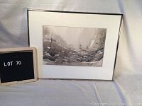 Framed watercolour painting displayed alongside lot sign showing 'Lot 70'.