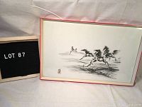 Photo of framed Asian ink painting showing four running horses, with a sign indicating lot number 87.