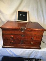 Front view of oak toolbox closed showing flip-up lid and front drawers