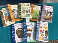 Full set of eight Miller's antiques and collectibles books laid out on blue surface showing front covers.