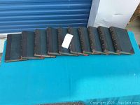 Ten volumes of 'The Bible Story' arranged on a blue cloth background.