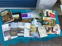 Seventeen landscape and history books displayed on a blue cloth, titles visible showing focus on Scotland, England, and Celtic regions.