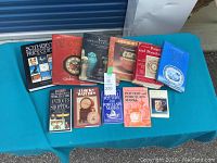 Photo showing all 11 books arranged on a blue surface, focused on pottery and porcelain guidance and antiques.