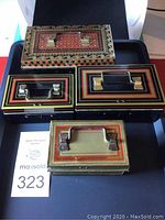 Photo showing all four vintage metal cases, different sizes and painted decorative designs