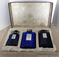 Set of three cobalt blue glass bottles in cream satin-lined presentation box with star pattern interior lid.