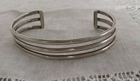 Front angle of vintage sterling silver modernist bangle showing triple band design and silver marks inside end.
