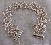 Detailed view of the entire sterling silver fancy link bracelet laid flat showing the double link chain and the tube-style clasp.