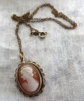 Front view of the vintage shell cameo pendant on the gold-tone scalloped frame with attached gilded sterling chain showing the cameo profile.