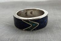 Close-up side view of vintage sterling silver ring with lapis lazuli and turquoise inlays, showing the zigzag pattern