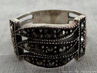 Close-up front view of sterling silver marcasite ring showing faceted marcasite stones and open work design.