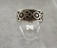 Front view of the sterling silver band ring showing the oxidized pressed design pattern in open cut-out style.