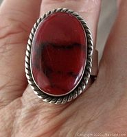 Top view showing oval deep red jasper stone in twisted sterling silver bezel setting on adjustable band.