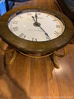 Top-down view of round wood and glass coffee table showing integrated clock face.