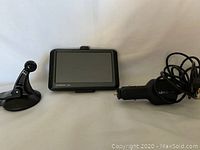 Front view of Garmin Nuvi GPS device, suction cup mount, and car charger cable.