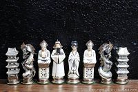 Eight white-glazed pieces in a row: pagoda rook, dragon knight, buddha bishop, emperor king, consort queen, buddha bishop, dragon knight, pagoda rook
