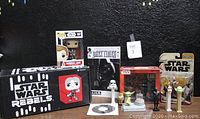 Photo showing the Star Wars Rebels Smugglers Bounty box, POP! General Leia bobblehead, Dark Times comic, vintage figures, PEZ dispensers, and Star Wars toys along with game CD.