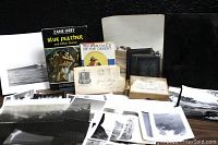 Photo shows the entire lot with books, envelopes, glass negatives, and photographs spread on a flat surface.