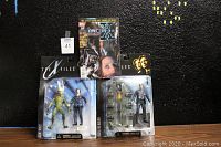 Photo of two X-Files action figures and one comic book laid out on a black surface, showing packaging and book cover.