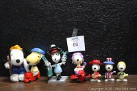 Full group of 7 vintage Snoopy collectibles including plush, various figurines in costumes holding items