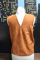 Front view of the rust-colored suede and knit sleeveless vest on a mannequin showing the V-neck and clean design.
